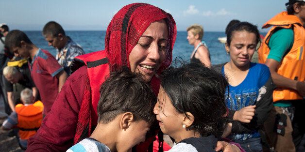 A Syrian woman embraces her children after they arrived from Turkey to Lesbos island, Greece, on a dinghy, Friday, Sept. 11, 2015. While migrants for years have taken death-defying trips across the Mediterranean to reach the relative peace and comfort of the Europe Union, the flow has hit record proportions this year _ notably with an influx of Syrians, Afghans and Eritreans fleeing trouble back home.(AP Photo/Petros Giannakouris)