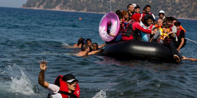 A Syrian man swims in front of a dinghy full of refugees that suffered engine failure as they approached Lesbos island, Greece, Friday, Sept. 11, 2015. While migrants for years have taken death-defying trips across the Mediterranean to reach the relative peace and comfort of the Europe Union, the flow has hit record proportions this year - notably with an influx of Syrians, Afghans and Eritreans fleeing trouble back home.(AP Photo/Petros Giannakouris)