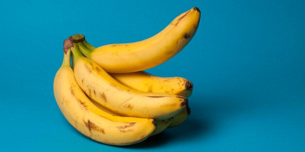 A bunch of bananas with one banana sticking up, suggestive of an erection