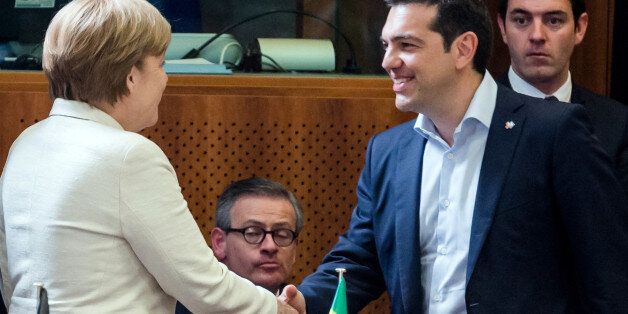 Greek Prime Minister Alexis Tsipras, right, shakes hands with German Chancellor Angela Merkel during a round table meeting at the EU-CELAC summit in Brussels on Wednesday, June 10, 2015. Greece's prime minister was hoping to meet with the leaders of Germany and France in Brussels Wednesday, in the latest effort to break a bailout negotiation deadlock that has revived fears his country could default and drop out of the euro. (AP Photo/Geert Vanden Wijngaert)