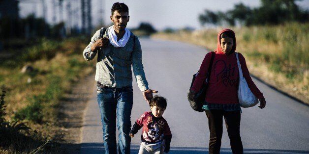 A migrant family walks on a road near the southern Serbian town of Presevo, near the border with Macedonia, on July 15, 2015. Migrants cross Serbia to join other European countries, as it has land borders with three EU countries - Romania, Hungary and Croatia. The estimated number of people crossing the Serbia-Hungary border has increased more than 25-fold, rising from 2,370 to 60,602 according to an Amnesty International report. AFP PHOTO/DIMITAR DILKOFF (Photo credit should read DIMITAR DILKOFF/AFP/Getty Images)