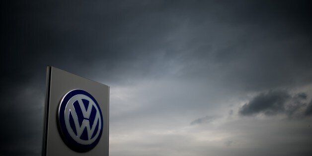 The logo of German car maker Volkswagen can be seen as dark clouds hang in the sky over a Volkswagen trader in Hanover, central Germany, on September 22, 2015. Share prices on the Frankfurt stock exchange fell more than 3.0 percent in midday trading on September 22, 2015, pushed down by index heavyweight Volkswagen, as it ploughed ever deeper into a pollution cheating scandal. AFP PHOTO / DPA / JULIAN STRATENSCHULTE +++ GERMANY OUT (Photo credit should read JULIAN STRATENSCHULTE/AFP/Getty Images)