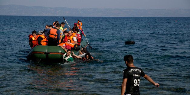 Migrant whose boat stalled at sea while crossing from Turkey to Greece approach the shore of the island of Lesbos, Greece, on Sunday, Sept. 20, 2015. A boat with 46 migrants or refugees has sunk Sunday in Greece and the coast guard says it is searching for 26 missing off the eastern Aegean island of Lesbos. (AP Photo/Petros Giannakouris)
