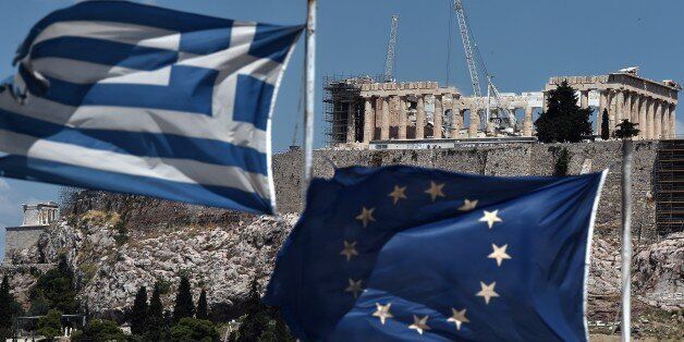 An EU and a Greek flag wave in front of the ancient temple of Parthenon atop the Acropolis hill in Athens on July 7, 2015. Eurozone leaders will hold an emergency summit in Brussels on July 7 to discuss the fallout from Greek voters' defiant 'No' to further austerity measures, with the country's Prime Minister Alexis Tsipras set to unveil new proposals for talks.. AFP PHOTO /ARIS MESSINIS (Photo credit should read ARIS MESSINIS/AFP/Getty Images)