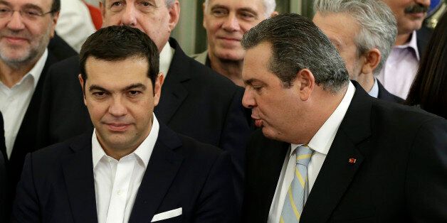 Greece's Prime Minister Alexis Tsipras, left, listens to Greek Defense Minister Panos Kammenos, who heads the government's junior coalition member Independent Greeks during a swearing in ceremony of the cabinet in Athens, Wednesday, Sept. 23, 2015. Greece's new leftist-led coalition government has formally assumed its duties, pledging to enforce creditor-demanded spending cuts and reforms while softening the pain on an austerity-weary population. (AP Photo/Thanassis Stavrakis)