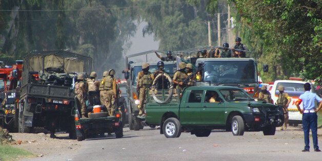 Pakistani army troops surround an air force base, Friday, Sept. 18, 2015 in Peshawar, Pakistan after the Taliban launched a brazen assault on the base on the outskirts of the northwestern city, storming a mosque inside the sprawling compound and killing many worshippers during prayers. (AP Photo/Mohammad Sajjad)