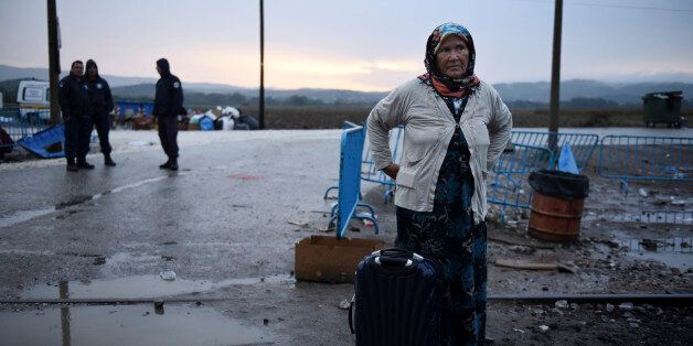 A woman waits with her bags to cross the border from the northern Greek village of Idomeni to southern Macedonia, Monday, Sept. 21, 2015. Hundreds of refugees and economic migrants arrive daily in Idomeni, a small village of some 100 inhabitants, to cross into Macedonia, from where they continue through Serbia and Hungary to seek asylum in wealthier European countries. (AP Photo/Giannis Papanikos)