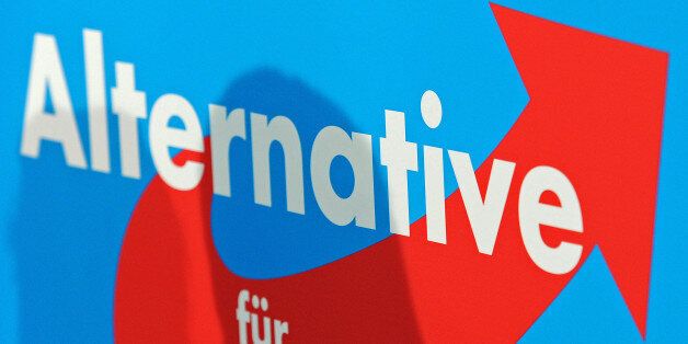 The shadow of top candidate of the Alternative for Germany, AfD, Bernd Lucke falls on the party's logo during a press conference after Germany's general election in Berlin, Monday, Sept. 23, 2013. The new anti-euro party reached 4.7 percent and will not be in the parliament for the next legislative period. (AP Photo/Jens Meyer)
