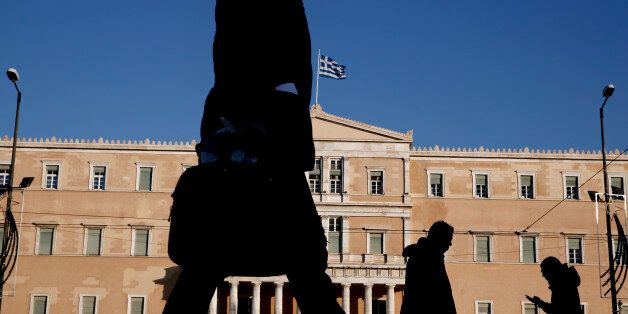 Pedestrian walks past the Greek parliament in central Athens, on Wednesday, Jan. 7, 2015. Greeks go to the polls to elect a new Parliament on Jan. 25, in an early snap general election triggered after lawmakers failed to agree on who will replace the countryâs president when his 5-year tenure expires in March. The elections, which the left-wing opposition Syriza party is tipped to win, albeit without enough votes to govern alone, come as the bailed-out country is edging out of a crippling