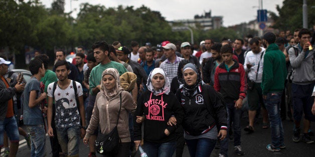 Migrants and refugees walk in the direction of Austria, Budapest, Hungary, Saturday, Sept. 5, 2015. Several hundred people started a march from Budapest's Keleti train station towards Austria on Saturday. (AP Photo/Marko Drobnjakovic)