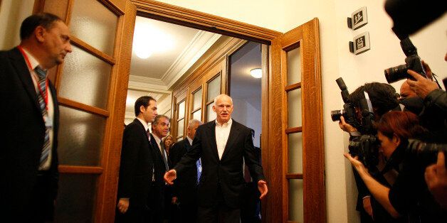 George Papandreou, Greece's prime minister, center, reacts to photographers as he arrives for a cabinet meeting in Athens, Greece, on Tuesday, Nov. 8, 2011. Papandreou resumed talks with his opposition rival in Athens today as they moved closer to agreement on naming the premier of a Greek unity government to secure a resumption of international aid. Photographer: Kostas Tsironis/Bloomberg via Getty Images