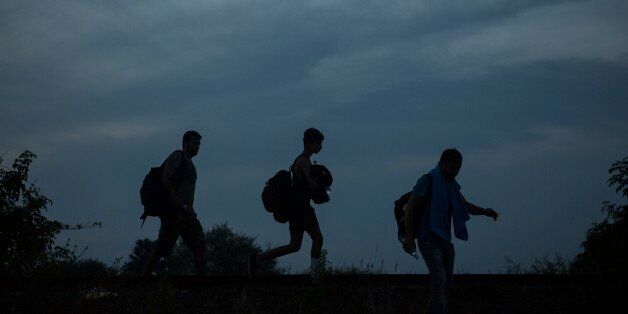 A group of people walk along the railway tracks near the town of Roszke, Hungary, on Thursday Sept. 3, 2015 after crossing the border from Serbia. The 28-nation European Union has been at odds for months on how to deal with the influx of more than 332,000 migrants this year as Greece, Italy and Hungary have pleaded for more help. (AP Photo/Santi Palacios)