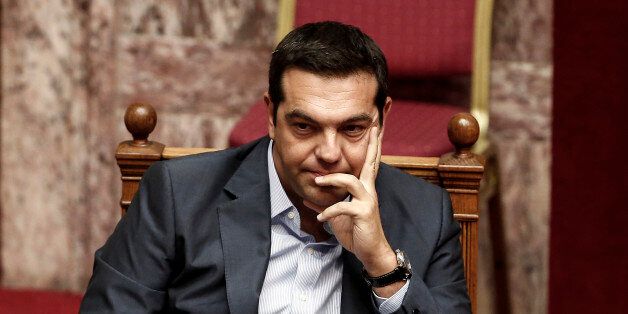 Alexis Tsipras, Greece's prime minister, pauses while attending a vote by lawmakers on a bailout deal in Athens, Greece, on Friday, Aug. 14, 2015. Greece's economy grew in the second quarter in a surprise surge just before the standoff between the government and its creditors forced officials to impose capital controls. Photographer: Yorgos Karahalis/Bloomberg via Getty Images