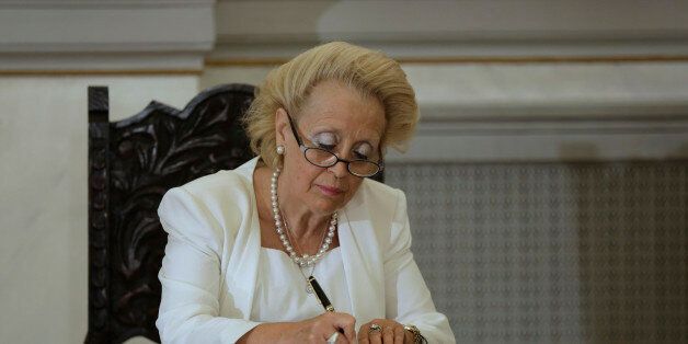 Vassiliki Thanou, signs a document during a swearing in ceremony at the Presidential Palace in Athens, Thursday, Aug. 27, 2015, to become Greece's first female prime minister. Greece came one step closer on Thursday to early elections with President Prokopis Pavlopoulos appointing the head of the country's Supreme Court as caretaker prime minister to lead the country to next month's polls.(AP Photo/Petros Giannakouris)