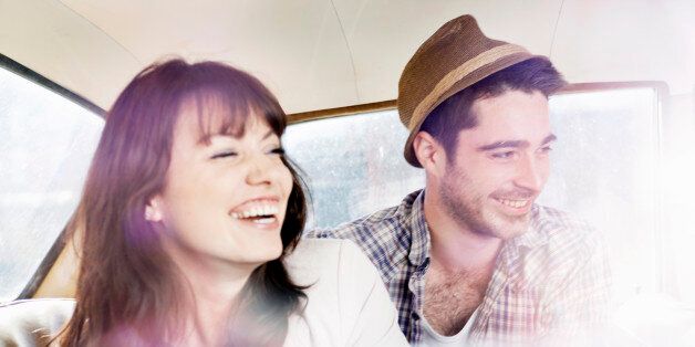 man and woman laughing in car