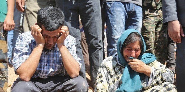 KOBANI, SYRIA - SEPTEMBER 4: Abdullah Kurdi (L), father of Syrian children Aylan, 2, his brother Galip, 3, and husband of Zahin Kurdi, 27, who drowned after their boat sank en route to the Greek islands in the Aegean Sea, mourns during funeral of his family in the Syrian border town of Kobani (Ayn al-Arab) on September 4, 2015. The 12 people, including eight children, drowned after their boat sank en route to the Greek islands in the Aegean Sea. (Photo by Isa Terli/Anadolu Agency/Getty Images)