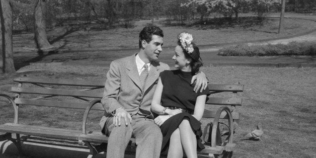 USA,New York,New York City,Happy young couple sitting on bench in park