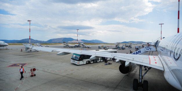 SANTORINI, GREECE - JUNE 10: People leave a parked airbus A320 from the flight company Aegean at the Santorini Airport field on June 10, 2015 in Santorini, Greece. Santorini is an island in the southern Argon Sea, about 200ÃÂ km southeast of Greece's mainland and forms the southernmost member of the Cyclades group of islands. Santorini was ranked the world's top island for many other magazines and travel sites, including the Travel+Leisure Magazine,the BBC, as well as the US News. (Photo by Christian Marquardt/Getty Images)