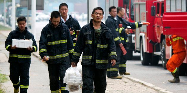 Chinese firefighter collect lunch as they wait near the site of an explosion in northeastern China's Tianjin municipality Saturday, Aug. 15, 2015. State media reported that the casualties of the first three squads of firefighters to respond and of a neighborhood police station have not yet been determined, suggesting that the death toll could still go up. (AP Photo/Ng Han Guan)
