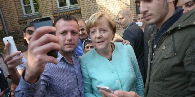 BERLIN, GERMANY - SEPTEMBER 10: German Chancellor Angela Merkel pauses for a selfie with a migrant before she visited the AWO Refugium Askanierring shelter for migrants on September 10, 2015 in Berlin, Germany. Merkel visited several facilities for migrants today, including an application center for asylum-seekers, a school with welcome classes for migrant children and a migrant shelter. Thousands of migrants are currently arriving in Germany every day, most of them via the Balkans and Austria.