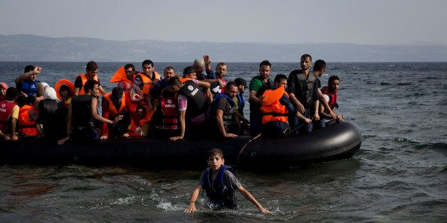 Syrian migrants arrive at the coast on a dinghy after crossing from Turkey, at the island of Lesbos, Greece, Monday, Sept. 7, 2015. The island of some 100,000 residents has been transformed by the sudden new population of some 20,000 refugees and migrants, mostly from Syria, Iraq and Afghanistan. (AP Photo/Petros Giannakouris)