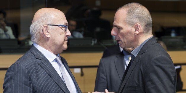 French Finance and Public Accounts Minister Michel Sapin (L) speaks with Greek Finance Minister Yanis Varoufakis (R) prior to an EcoFin Ministers meeting at the EU Council headquarters in Luxembourg on June 19, 2015. AFP PHOTO / THIERRY MONASSE (Photo credit should read THIERRY MONASSE/AFP/Getty Images)