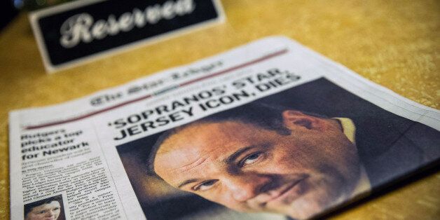 BLOOMFIELD, NJ - JUNE 20: Flowers and a copy of the Newark Star-Ledger sit at the booth where the final scene of the final episode of the HBO show, 'The Sopranos,' was filmed, at Holsten's restaurant on June 20, 2013 in Bloomfield, New Jersey. 'Sopranos' star James Gandolfini, who played the troubled mob boss Tony Soprano, died at age 51 yesterday in Rome. (Photo by Andrew Burton/Getty Images)