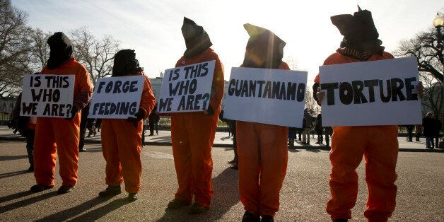 Protestors dressed as Guantanamo detainees gather in front of the White House, Sunday, Jan. 11, 2015, in Washington, during a rally to commemorate the 13th anniversary of detainees at Guantanamo Bay. (AP Photo/Manuel Balce Ceneta)