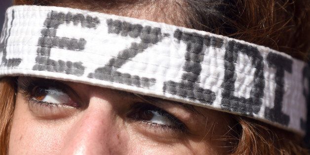 A demonstrator wears a headband reading Yazidis , in Hannover,Â Germany, Saturday Aug. 16, 2014. Thousands of people in Germany have protested against the persecution of the Yazidi minority in Iraq. Police say at least 10,000 people attended the biggest demonstration in the north German city of Hannover on Saturday. Protesters carried banners demanding that the international community protect the Yazidi people and other minorities from the Islamist State extremist group. (AP Photo/dpa,Swen Pfoertner)