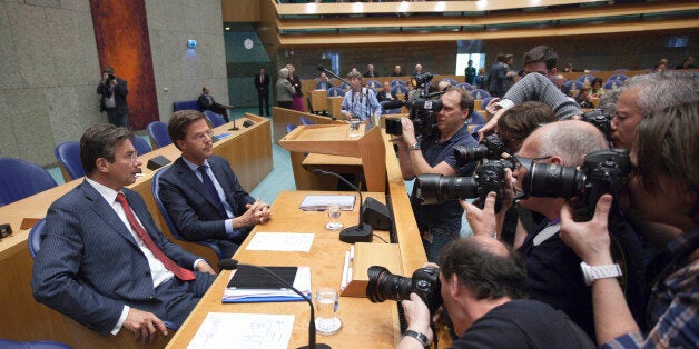 Photographers and cameramen crowd around caretaker Prime Minister Mark Rutte, second left, and deputy prime minister Maxime Verhagen, left, in parliament in The Hague, Netherlands, Tuesday April 24, 2012. Rutte appealed to a polarized Dutch Parliament on Tuesday to help him get the economy back on track rather than let the country drift in political limbo until new elections. Speaking publicly for the first time since he tendered his resignation Monday, Rutte said the nation, long considered one of Europe's most fiscally responsible, has no time to waste in tackling its economic woes. (AP Photo/Peter Dejong)