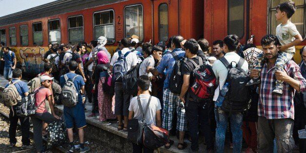 Migrants wait for a train heading to the border with Serbia at the train station of Gevgelija, on the Macedonian-Greek border, on August 11, 2015. The EU announced August 11 that it has approved 2.4 billion euros ($2.6 billion) of funding to help member states over the next few years cope with the flood of migrants entering the bloc. AFP PHOTO / DIMITAR DILKOFF (Photo credit should read DIMITAR DILKOFF/AFP/Getty Images)