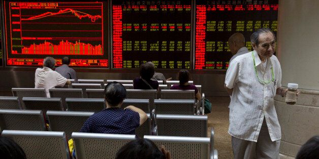 Investors monitor stock prices at a brokerage in Beijing, Friday, Aug. 21, 2015. Asian stocks fell further Friday after a survey showed Chinese manufacturing weakened this month. (AP Photo/Ng Han Guan)