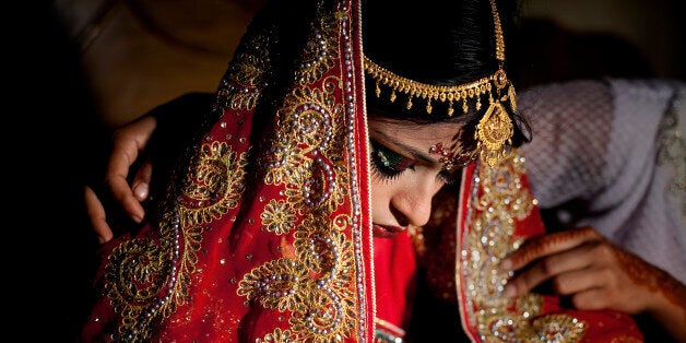 MANIKGANJ, BANGLADESH - AUGUST 20: 15 year old Nasoin Akhter is consoled by a friend on the day of her wedding to a 32 year old man, August 20, 2015 in Manikganj, Bangladesh. In June of this year, Human Rights Watch released a damning report about child marriage in Bangladesh. The country has one of the highest rates of child marriage in the world, with 29% of girls marrying before the age of 15, and 65% of girls marrying before they turn 18. The detrimental effects of early marriage on a girl cannot be overstated. Most young brides drop out of school. Pregnant girls from 15-20 are twice as likely to die in childbirth than those 20 or older, while girls under 15 are at five times the risk. Research cites spousal age difference as a significant risk factor for violence and sexual abuse. Child marriage is attributed to both cultural tradition and poverty. Parents believe that it 'protects' girls from sexual assault and harassment. Larger dowries are not required for young girls, and economically, women's earnings are insignificant as compared to men's. (Photo by Allison Joyce/Getty Images)