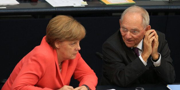 Wolfgang Schaeuble, Germany's finance minister, right, speaks to Angela Merkel, Germany's chancellor, during a debate in the lower-house of the Bundestag in Berlin, Germany, on Friday, July 17, 2015. German lawmakers have their say on Greece's next bailout on Friday after European Central Bank President Mario Draghi said he views the country's place in the euro as secure. Photographer: Krisztian Bocsi/Bloomberg via Getty Images