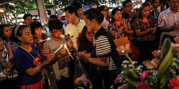 People light candles and pray for the victims of a bomb blast at the reopened Erawan shrine in Bangkok, Thailand, on Wednesday, Aug. 19, 2015. Bangkok's deadly bomb attack this week is set to hit Thailand's last remaining growth pillar with travel warnings and canceled trips, adding pressure on authorities to restore confidence and stimulate the economy. Photographer: Dario Pignatelli/Bloomberg via Getty Images