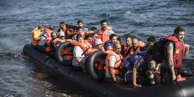 An inflatable boat with Syrian migrants approaches the coast of Lesbos island after crossing the Aegean sea from Turkey, on August 22, 2015. Turkish security forces have detained 435 migrants and Syrian refugees along with three suspected people smugglers, before they embarked on an attempt to cross the Aegean Sea to Greece, reports said. There has been an upsurge this summer in the numbers of refugees and migrants using shaky vessels to make the crossing, sparking a humanitarian crisis for the European Union. AFP PHOTO / ACHILLEAS ZAVALLIS (Photo credit should read ACHILLEAS ZAVALLIS/AFP/Getty Images)