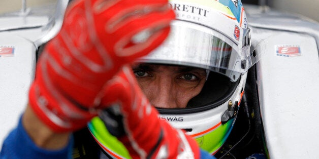 Justin Wilson, of England, dons his gloves as he prepares to drive during practice for the Indianapolis 500 auto race at Indianapolis Motor Speedway in Indianapolis, Thursday, May 14, 2015. (AP Photo/Michael Conroy)