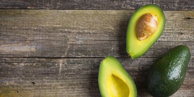 food background with fresh organic avocado on old wooden table, top view, copy space