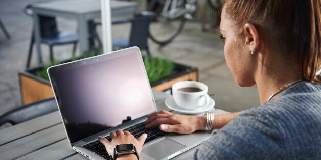 Portrait of a woman wearing an Apple Watch while sitting outside a cafe with an Apple MacBook, taken on May 21, 2015. (Photo by Joseph Branston/Future Publishing via Getty Images)