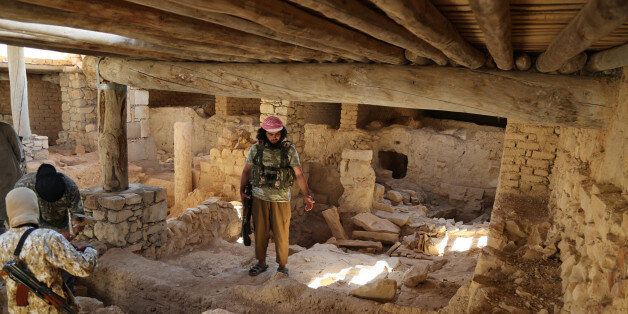 This picture released late Thursday, Aug. 20, 2015, by an Islamic State militant-affiliated website, shows Islamic State Milittants standing inside the ancient monastery of the Saint Eliane, near the town of Qaryatain which IS captured in early August, in Homs province, Syria. A priest and activists say the Islamic State group has demolished an ancient monastery in central Syria. A Christian clergyman told The Associated Press in Damascus that IS militants also wrecked a church inside the monastery that dates back to the first Christian centuries. The priest, who spoke Friday on condition of anonymity for fear of reprisals, said the monastery included an Assyrian Catholic church. (Islamic State militant website via AP)