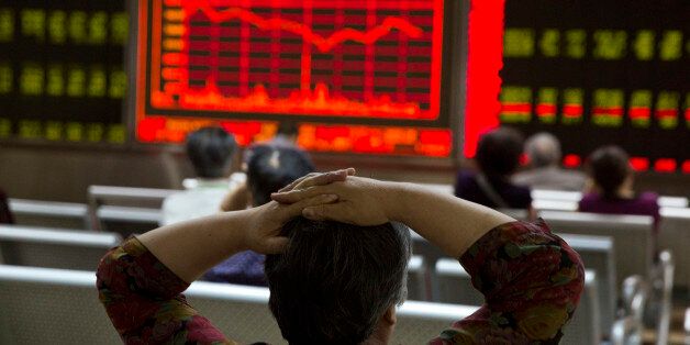 An investor watches a display of stock prices at a brokerage in Beijing, Friday, Aug. 21, 2015. Asian stocks fell further Friday after a survey showed Chinese manufacturing weakened this month. (AP Photo/Ng Han Guan)