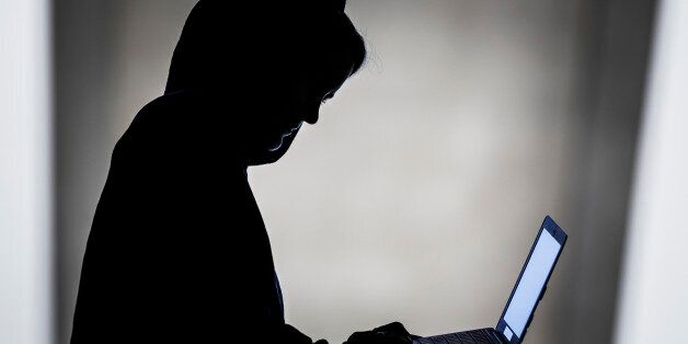 BERLIN, GERMANY - AUGUST 20: Symbolic feature with topic online crime, data theft and piracy and hacker, here the silhouette of a person with a laptop in his hands, on Augut 20, 2015 in Berlin, Germany. (Photo by Thomas Trutschel/Photothek via Getty Images)