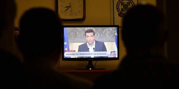 Journalists watch the televised address to nation of the Greek Prime Minister Alexis Tsipras in Athens on August 20, 2015. Tsipras announced his resignation and called for early elections in the crisis-hit country, widely expected to be held on September 20. 'I will shortly meet with the president of the republic and present my resignation and that of my government,' Tsipras said in a televised address to the nation. AFP PHOTO/ LOUISA GOULIAMAKI (Photo credit should read LOUISA GOULIAMAKI/AFP/Getty Images)