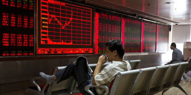 A Chinese investor monitors stock prices at a brokerage in Beijing on Wednesday, Aug. 26, 2015. Asian stocks rose Wednesday after a rocky start following Beijing's decision to cut a key interest rate to help stabilize gyrating financial markets and free up more funding to counter short liquidity. (AP Photo/Ng Han Guan)