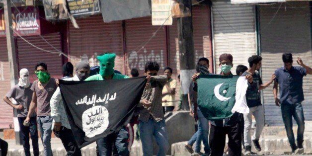 SRINAGAR, INDIA - JUNE 27: Kashmiri protesters displaying the flags of ISIS and Pakistan during a protest against alleged desecration of Jamia Masjid by police personnel yesterday after Friday prayers, on June 27, 2015 in Srinagar, India. Clashes broke out in several parts of downtown Srinagar on Saturday against the alleged desecration of Jamia Masjid by government forces yesterday. Reacting very sharply against police action, Auqaf Jamia Masjid, which functions under Mirwaiz, called for a shut