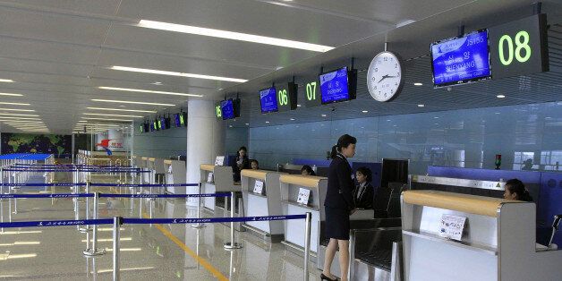 Staff wait at the check-in counters of the new international airport terminal building at Pyongyang airport, Wednesday, July 1, 2015, in Pyongyang, North Korea. The unveiling Wednesday underscores an effort to attract more tourists and to spruce up the country ahead of the celebration of a major anniversary of the founding of its ruling Worker's Party in October this year. (AP Photo/Kim Kwang Hyon)