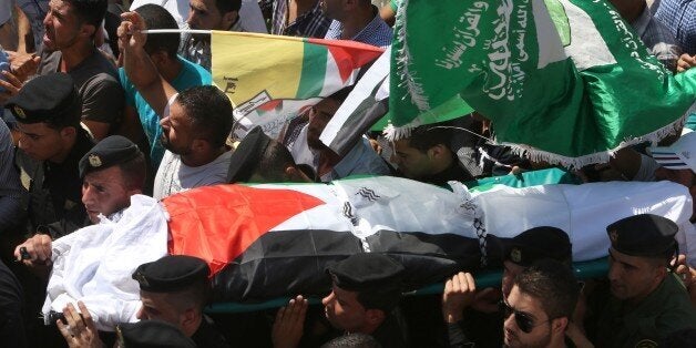 Members of the Palestinian security forces carry the body of Saad Dawabsha, the father of a Palestinian toddler killed last week when their home was firebombed by Jewish extremists, during his funeral in the West Bank village of Duma on August 8, 2015. Dawabsha succumbed in hospital in the southern Israeli city of Beersheba where he was being treated for third degree burns while his wife Riham and four-year-old son Ahmed are still fighting for their lives. AFP PHOTO / JAAFAR ASHTIYEH (Pho