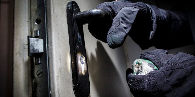 BERLIN, GERMANY - JUNE 27: Posed scene of a man opening a door with gloves and flashlight on June 27, 2014, in Berlin, Germany. The photo symbolizes the increasing risk of burglary in Germany. (Photo by Thomas Trutschel/Photothek via Getty Images)