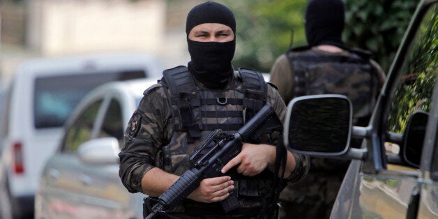 Masked Turkish police officers secure a road leading to the U.S. Consulate building in Istanbul, Monday, Aug. 10, 2015. Two assailants opened fire at the building on Monday, touching off a gunfight with police before fleeing the scene, Turkish media reports said. (AP Photo/Lefteris Pitarakis)