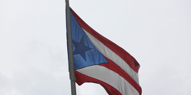 SAN JUAN, PUERTO RICO - JULY 01: The Puerto Rican flag flies near the Capitol building as the island's residents deal with the government's $72 billion debt on July 1, 2015 in San Juan, Puerto Rico. Governor of Puerto Rico Alejandro GarcÃa Padilla said in a speech recently that the people of Puerto Rico will have to make sacrifices and share the responsibilities to help pull the island out of debt. (Photo by Joe Raedle/Getty Images)